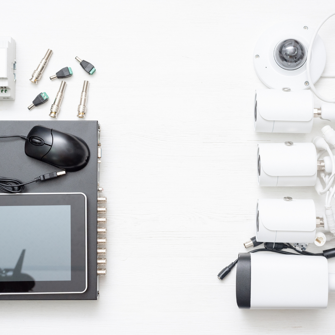 The image shows various surveillance equipment components arranged on a white background.These are components of a security camera system, possibly ready for setup or installation.