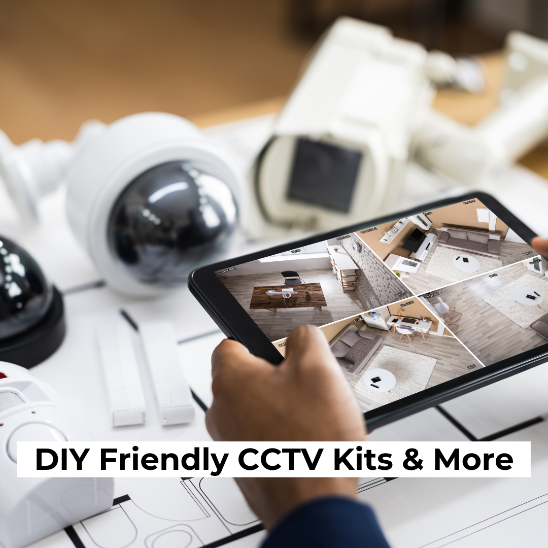 A person's hand holds a tablet displaying live surveillance footage of various rooms in a house. On the table in the foreground, multiple CCTV camera models are spread out alongside some paperwork. The text "DIY Friendly CCTV Kits & More" is prominently displayed at the bottom of the image.